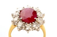 Lot 979 - A ruby and diamond cluster ring, the central...