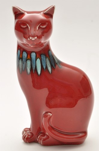 Lot 1048 - Poole: figure of a cat, red glaze with blue...
