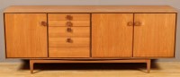 Lot 1164 - A 1970's teak sideboard, fitted drawers and...