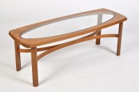 Lot 1185 - A 1970's tea coffee table, the oval glazed top...