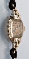 Lot 620 - A diamond set 14ct. white gold cased Bulova...