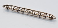 Lot 674 - An Edwardian diamond bar brooch, the nine...