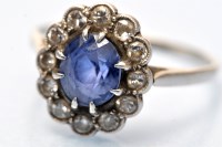 Lot 686 - A sapphire and diamond cluster ring, the oval...