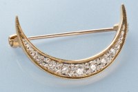 Lot 765 - A diamond crescent brooch, set in 9ct. yellow...