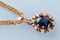 Lot 767 - A sapphire and diamond pendant, the oval facet...