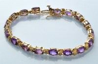 Lot 770 - An amethyst and 9ct. yellow gold bracelet,...