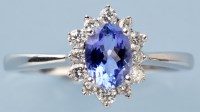 Lot 777 - A tanzanite and diamond cluster ring, the oval...