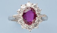 Lot 785 - A ruby and diamond cluster ring, the oval...