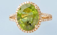 Lot 805 - A peridot and diamond cluster ring, the oval...