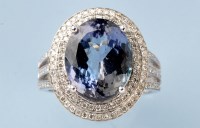 Lot 806 - A tanzanite and diamond cluster ring, the oval...