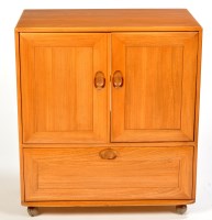 Lot 25 - Ercol: a light stained elm television cabinet,...
