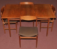 Lot 75 - A teak extending dining table and four dining...