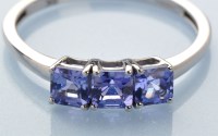 Lot 838 - A three stone tanzanite ring, the asscher cut...