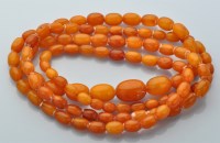 Lot 855 - A single row graduated amber bead necklace,...