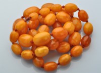 Lot 856 - A single row graduated amber bead necklace,...