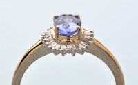 Lot 887 - A tanzanite and diamond cluster ring, the oval...