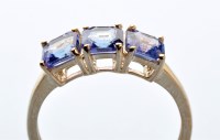 Lot 889 - A three stone tanzanite ring, the square facet...