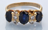 Lot 934 - A sapphire and diamond ring, three graduated...