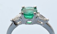 Lot 953 - An emerald and diamond ring, with a circular...