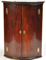 Lot 1369 - A George III mahogany bowfront hanging corner...