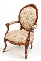 Lot 1378 - A Victorian walnut easy chair, flower carved...