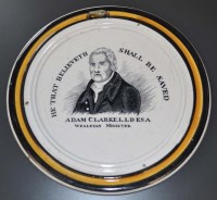 Lot 377 - A circular Adam Clarke plaque, black and...