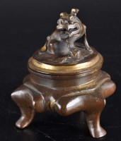 Lot 467 - A bronze and partially gilded tripod censer,...