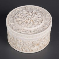 Lot 473 - A round ivory box, the base carved with a...
