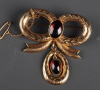 Lot 824 - A garnet and gold brooch, the oval cabouchon...