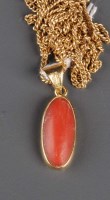 Lot 827 - A coral and gold pendant, the oval cabouchon...