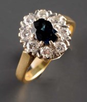 Lot 823 - A sapphire and diamond cluster ring, the oval...