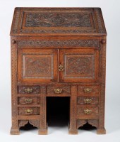 Lot 987 - A carved oak bureau with rectangular fall flap...