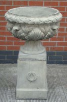 Lot 1121 - A composition garden urn, with wreath pattern...