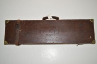 Lot 595 - A leather on wood gun case, with brass corner...