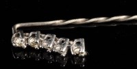 Lot 874 - A diamond stick pin, set with five brilliant...