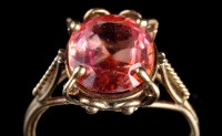 Lot 887 - An orange sapphire ring, the oval facet cut...