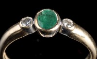 Lot 947 - An emerald and diamond ring, the oval facet...