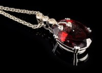 Lot 956 - A garnet and diamond set pendant, the oval...