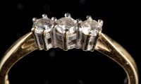 Lot 969 - A three stone diamond ring, the slightly...