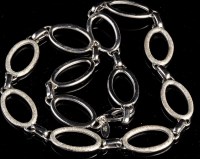 Lot 974 - A 14ct. white gold necklace, the lower oval...