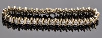 Lot 975 - A diamond bracelet, set with thirty-five...