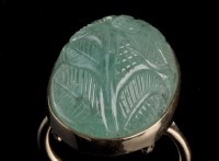 Lot 979 - A carved green stone ring, decorated with...