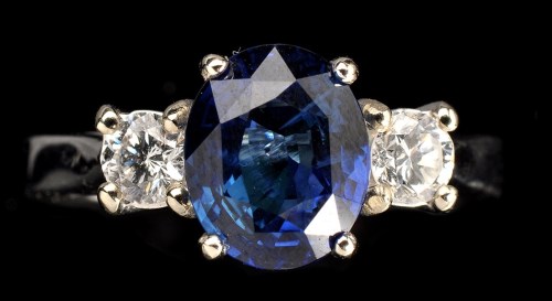 Lot 1008 - A sapphire and diamond ring, the oval facet...
