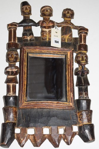 Lot 154 - An African tribal carved wooden framed mirror.