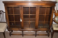 Lot 1268 - A mid 20th Century oak bookcase, the glazed...