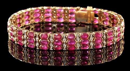 Lot 375 - A ruby and diamond bracelet, set with links of...