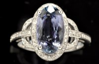 Lot 385 - A tanzanite and diamond cluster ring, the oval...