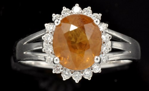 Lot 387 - An orange sapphire and diamond cluster ring,...