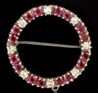 Lot 485 - A ruby and diamond circular brooch, set with...