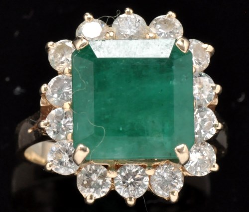 Lot 516 - An emerald and diamond cluster ring, the...